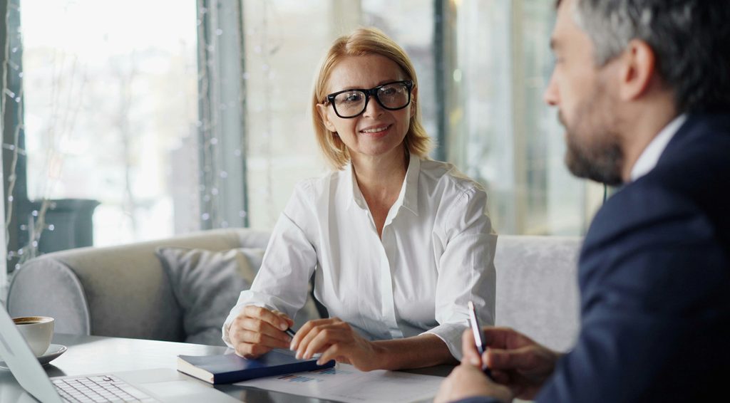 An advisor smiling across the desk during a client meeting